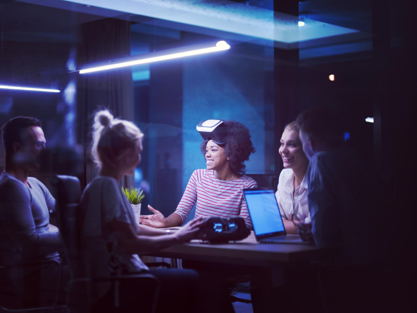 Multiethnic Business team using virtual reality headset in night office meeting Developers meeting with virtual reality simulator around table in creative office. Working on a Usability project.